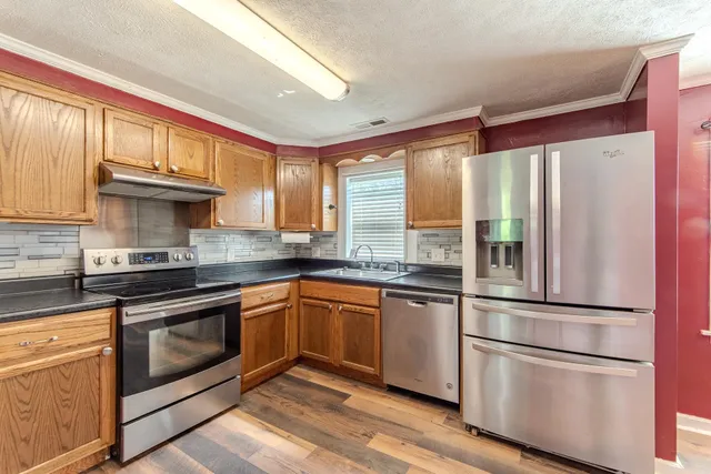 a kitchen with stainless steel appliances granite countertop a refrigerator sink and cabinets