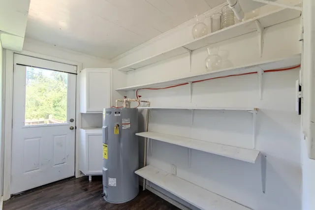 a view of a storage & utility room with refrigerator and windows