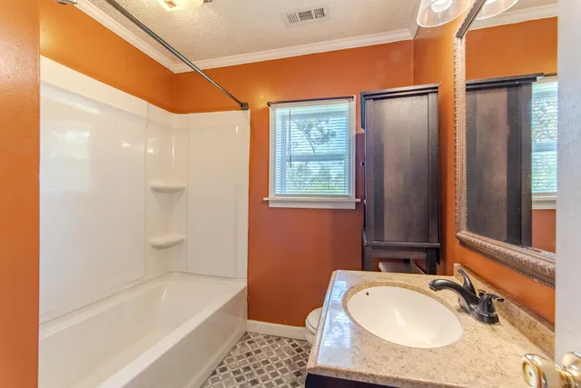 a bathroom with a tub sink and mirror