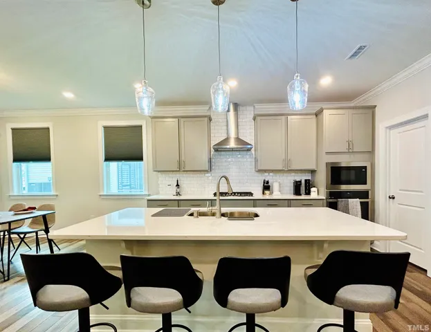 a kitchen with a dining table chairs stainless steel appliances and cabinets