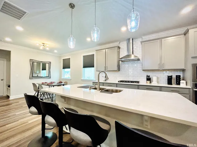 a kitchen with a dining table chairs stainless steel appliances and cabinets