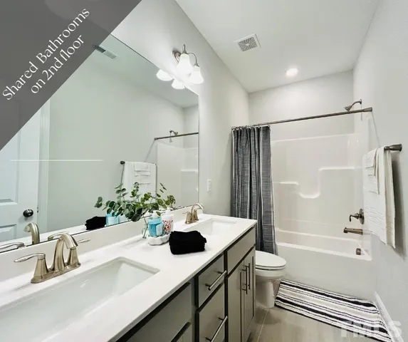 a bathroom with a bathtub shower sink vanity and toilet