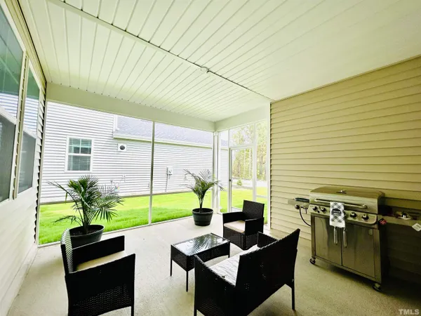 a backyard of a house with potted plants and a large tree