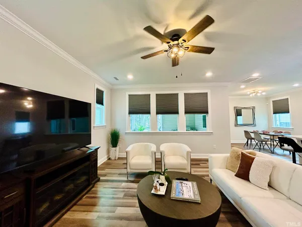 a living room with furniture and a flat screen tv with wooden floor