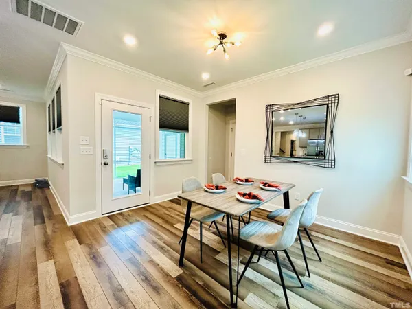 a dining room with furniture a window and wooden floor
