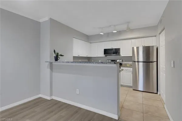 a kitchen with stainless steel appliances granite countertop a refrigerator sink and microwave