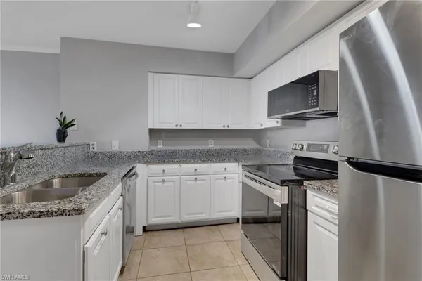 a kitchen with stainless steel appliances granite countertop a sink stove and microwave