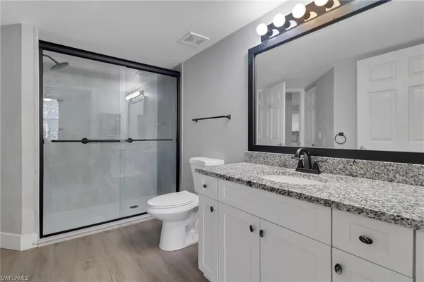 a bathroom with a granite countertop sink toilet and shower