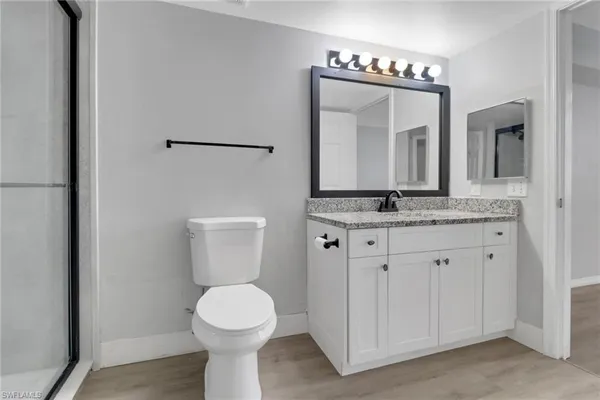 a bathroom with a granite countertop toilet sink and mirror