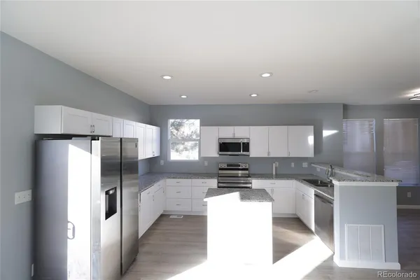 a kitchen with stainless steel appliances a refrigerator and a stove top oven