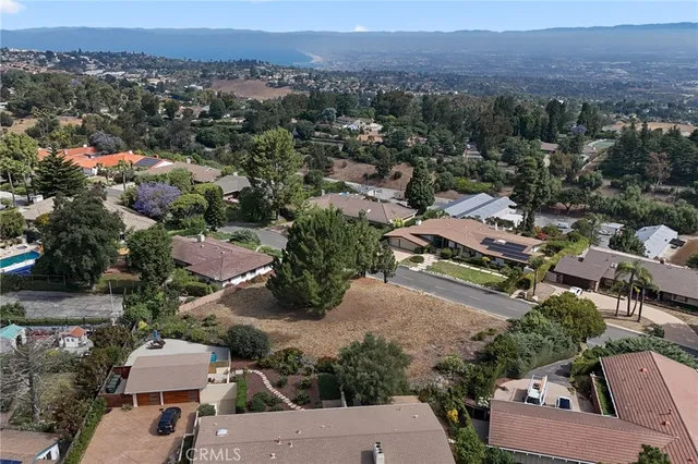 an aerial view of a city with lots of residential buildings and mountain view in back