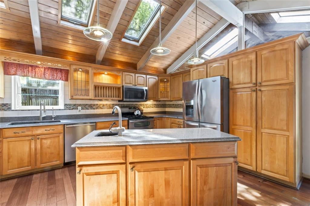 106 Sunset Street McKees Rocks, PA 15136 - Photo 12 of 45 a kitchen with stainless steel appliances granite countertop a refrigerator a sink dishwasher a stove and white countertops with wooden floor