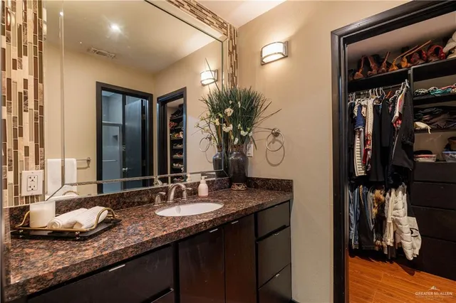 a en suite bathroom with a granite countertop sink and a mirror