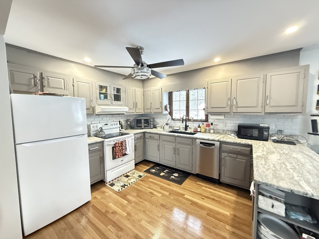 2 Blacksnake Road Salisbury, MA 01952 - Photo 10 of 31 a kitchen with a refrigerator stove and white cabinets