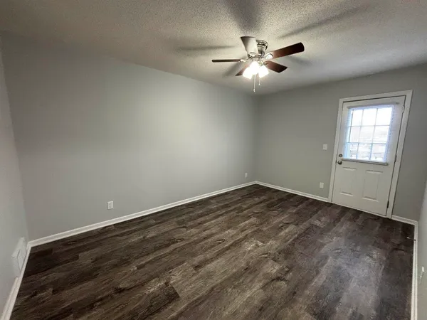 an empty room with closet and windows