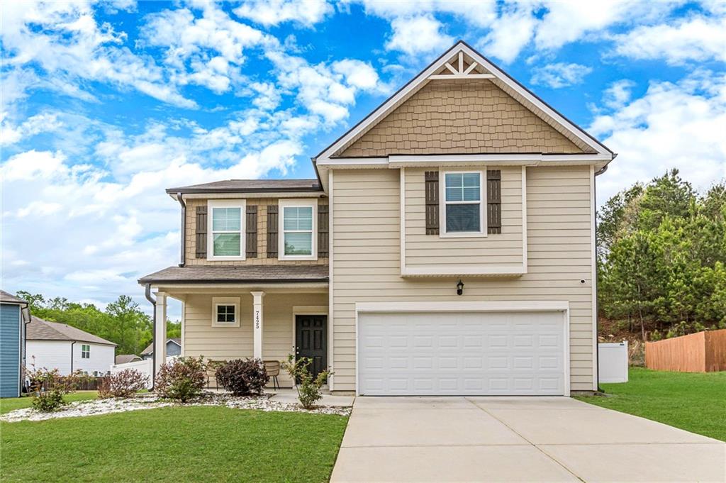 a front view of a house with a yard and trees