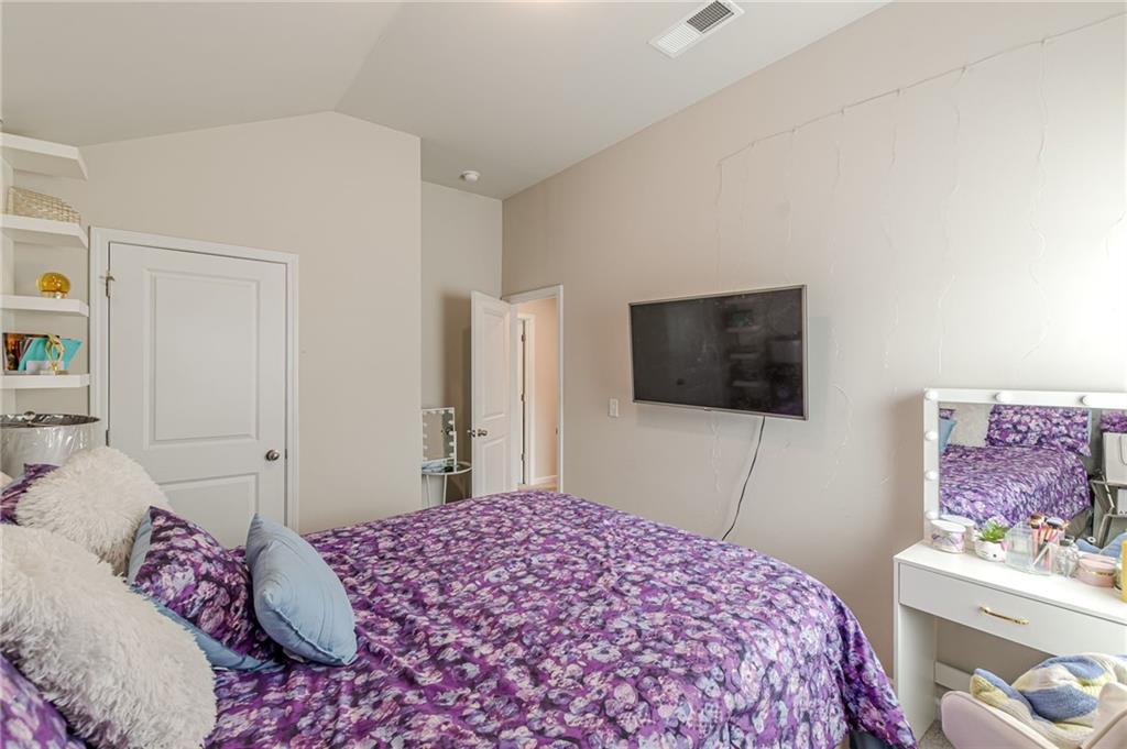 7425 Faith Street Fairburn, GA 30213 - Photo 17 of 29 a bedroom with a bed and a flat screen tv