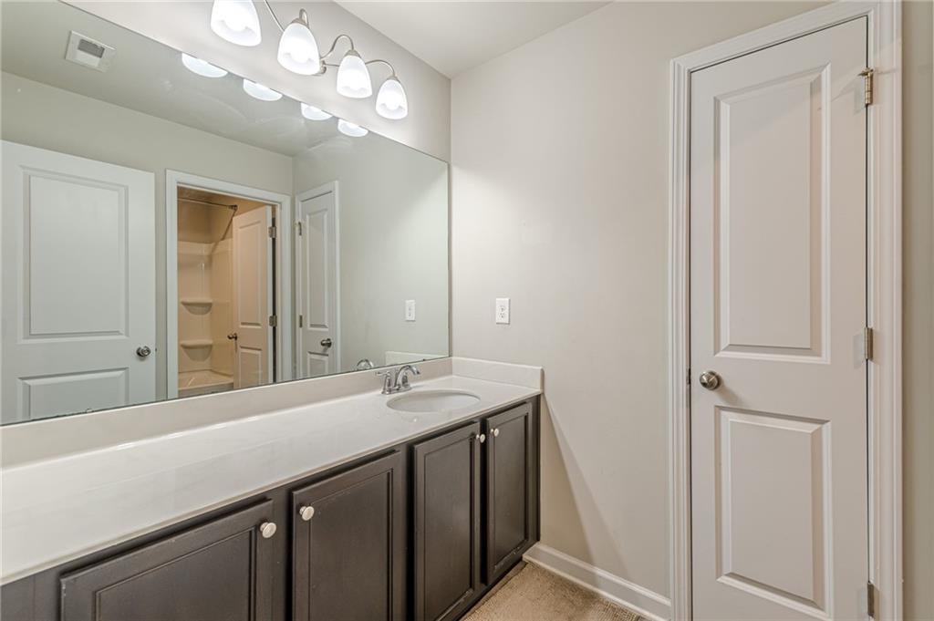 7425 Faith Street Fairburn, GA 30213 - Photo 18 of 29 a bathroom with a sink a vanity and a mirror