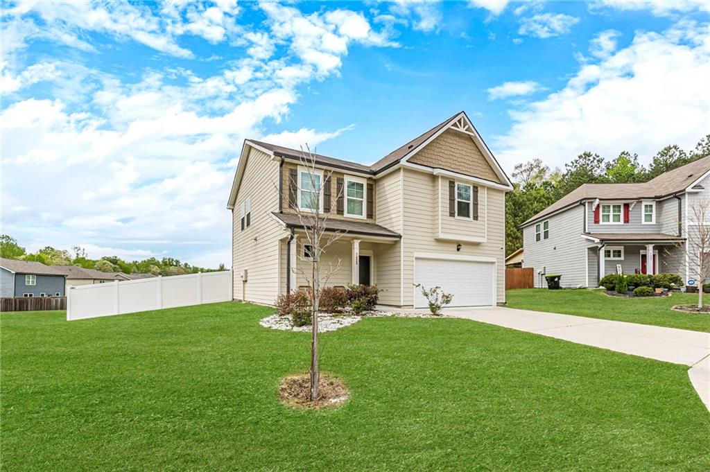 7425 Faith Street Fairburn, GA 30213 - Photo 2 of 29 a front view of a house with a garden and plants
