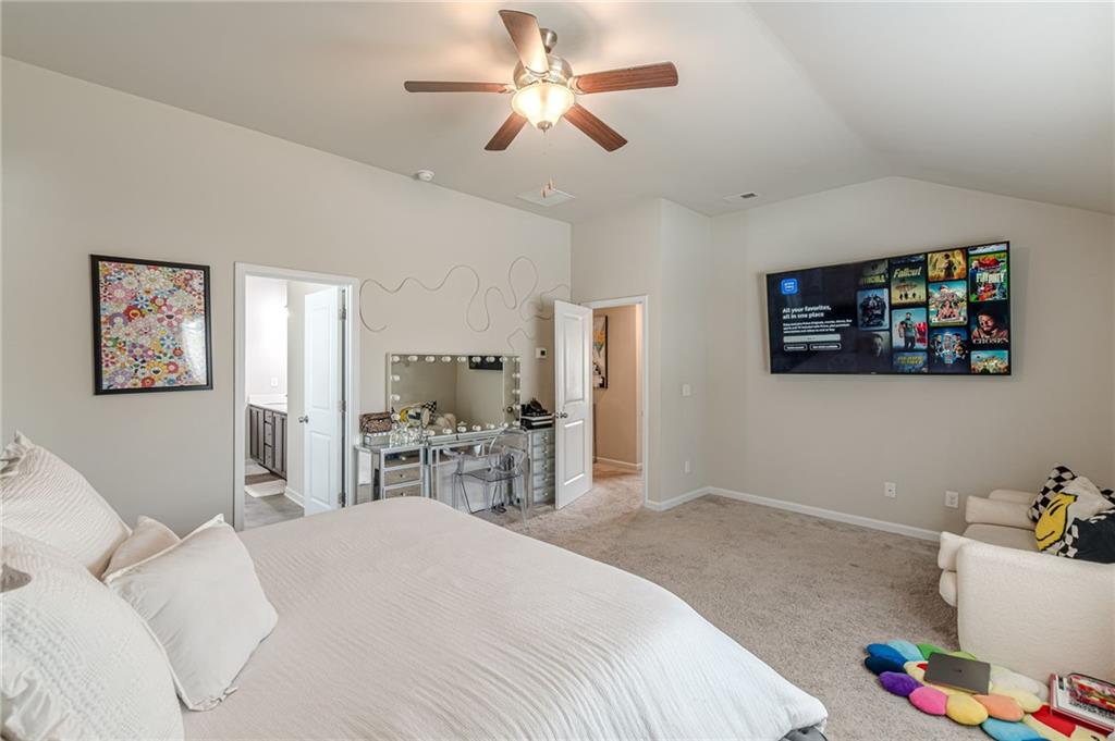 7425 Faith Street Fairburn, GA 30213 - Photo 22 of 29 a bedroom with a bed a table and painting