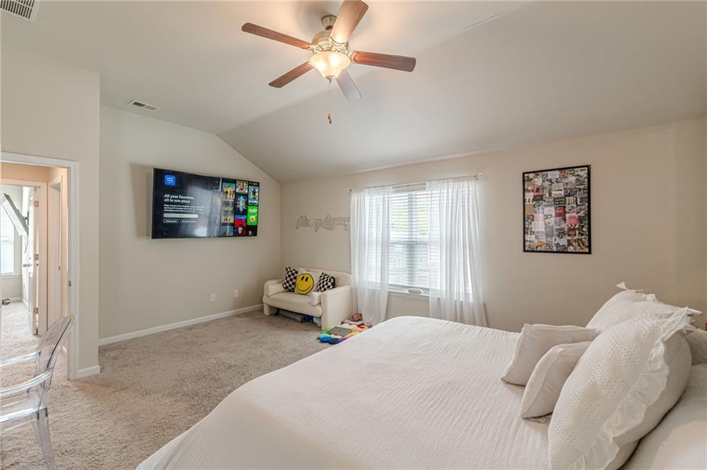 7425 Faith Street Fairburn, GA 30213 - Photo 23 of 29 a bedroom with a bed and a chandelier