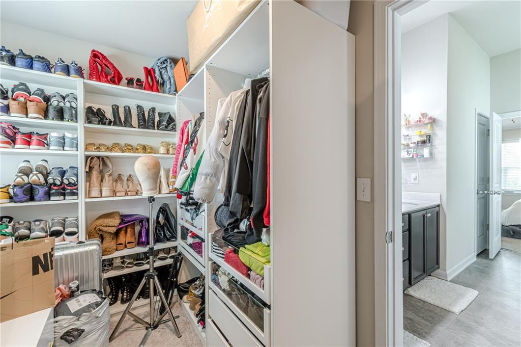 7425 Faith Street Fairburn, GA 30213 - Photo 27 of 29 a view of walk in closet with clothes and shoes