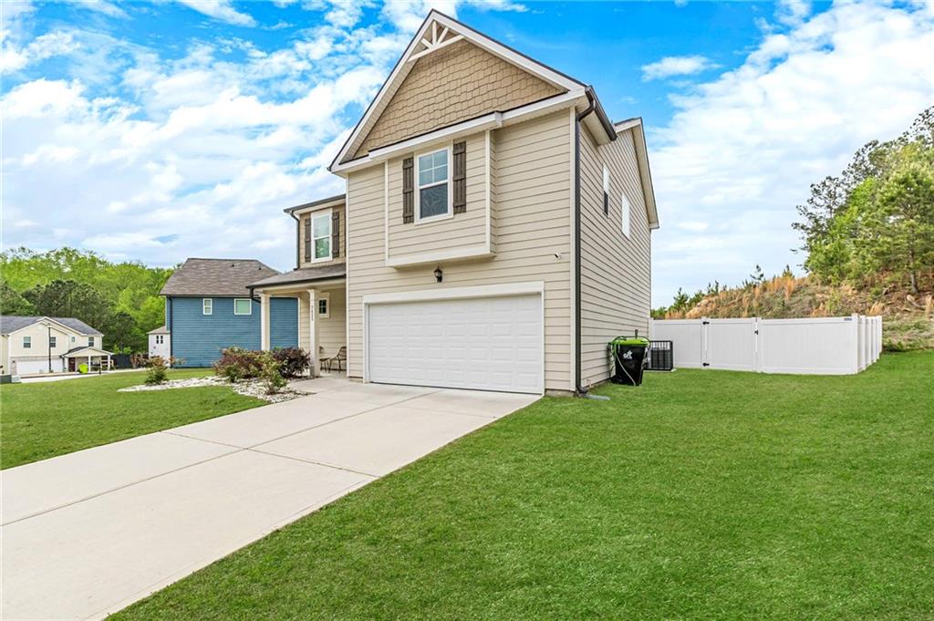 7425 Faith Street Fairburn, GA 30213 - Photo 3 of 29 a front view of a house with a yard and garage
