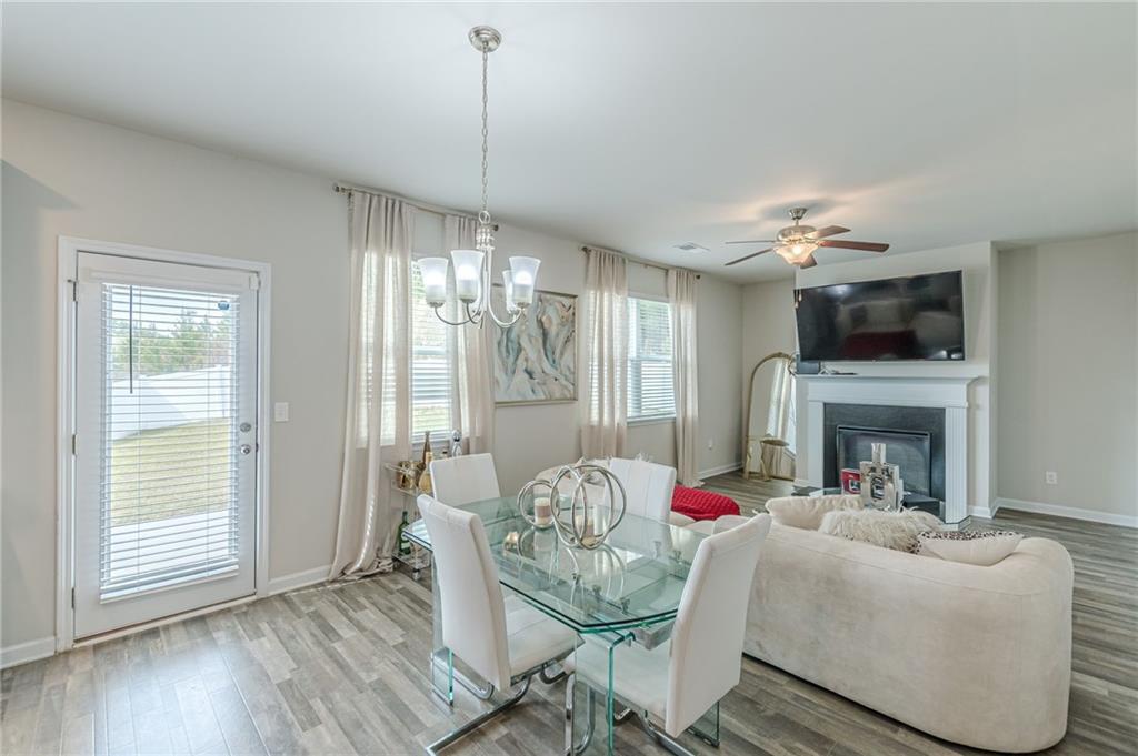 7425 Faith Street Fairburn, GA 30213 - Photo 7 of 29 a living room with furniture a fireplace and a chandelier