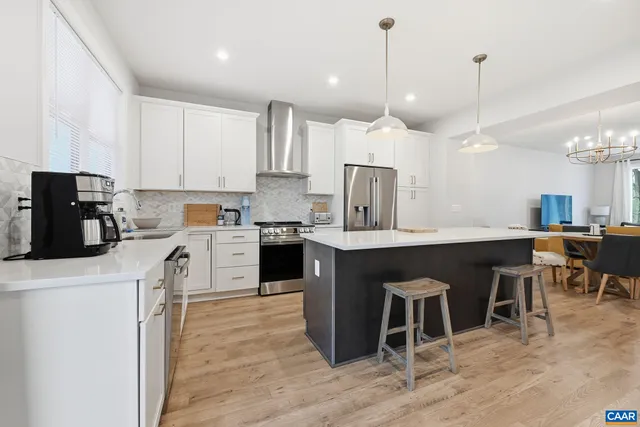a kitchen with stainless steel appliances a sink a stove a refrigerator and cabinets