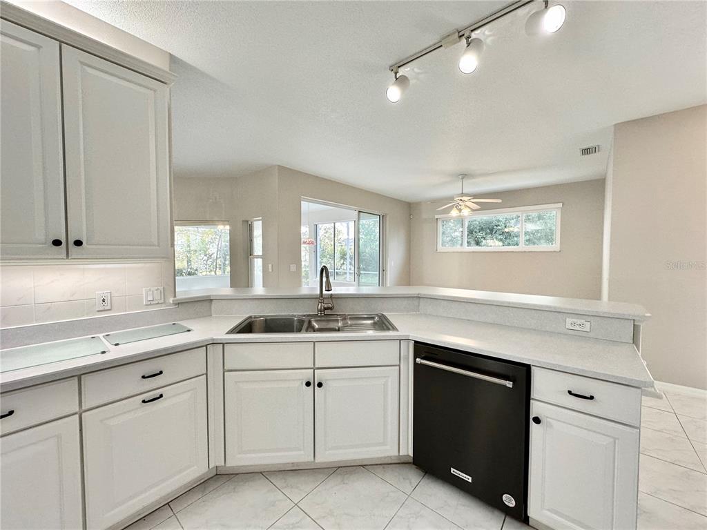 16 Westbrook Lane Palm Coast, FL 32164 - Photo 11 of 42 a kitchen with white cabinets appliances a sink and a window
