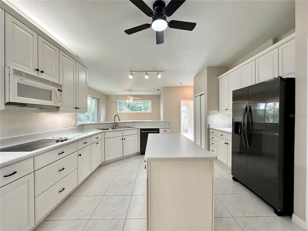 16 Westbrook Lane Palm Coast, FL 32164 - Photo 13 of 42 a large kitchen with stainless steel appliances kitchen island granite countertop a refrigerator and a sink