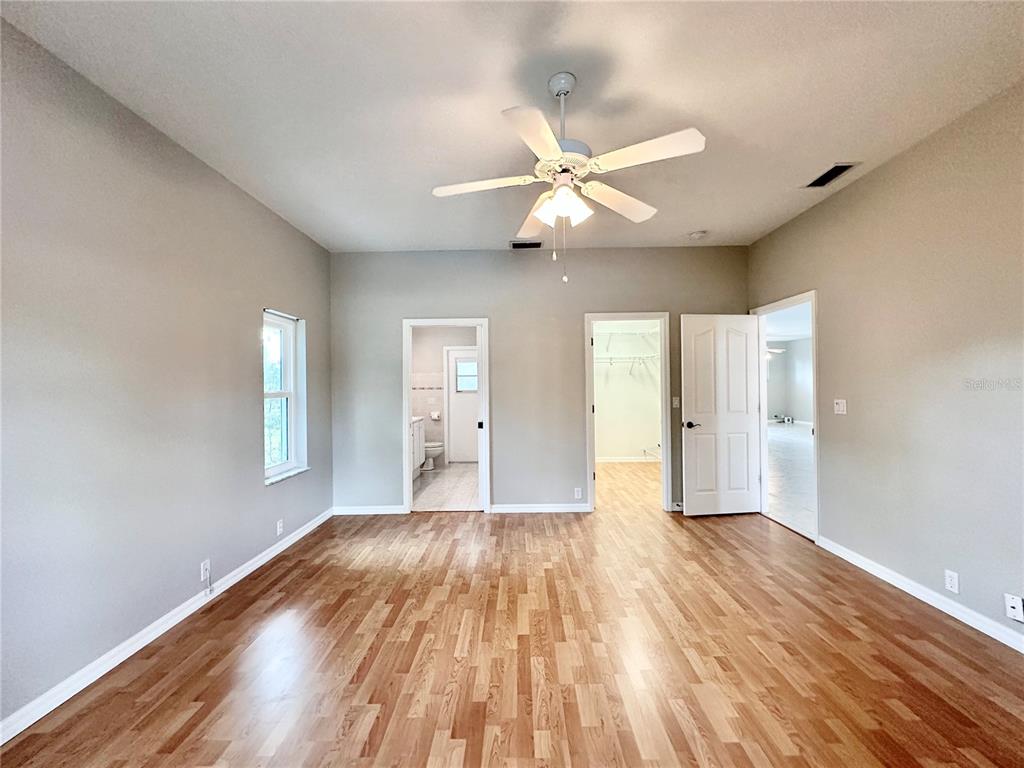 16 Westbrook Lane Palm Coast, FL 32164 - Photo 22 of 42 a view of empty room with wooden floor and fan