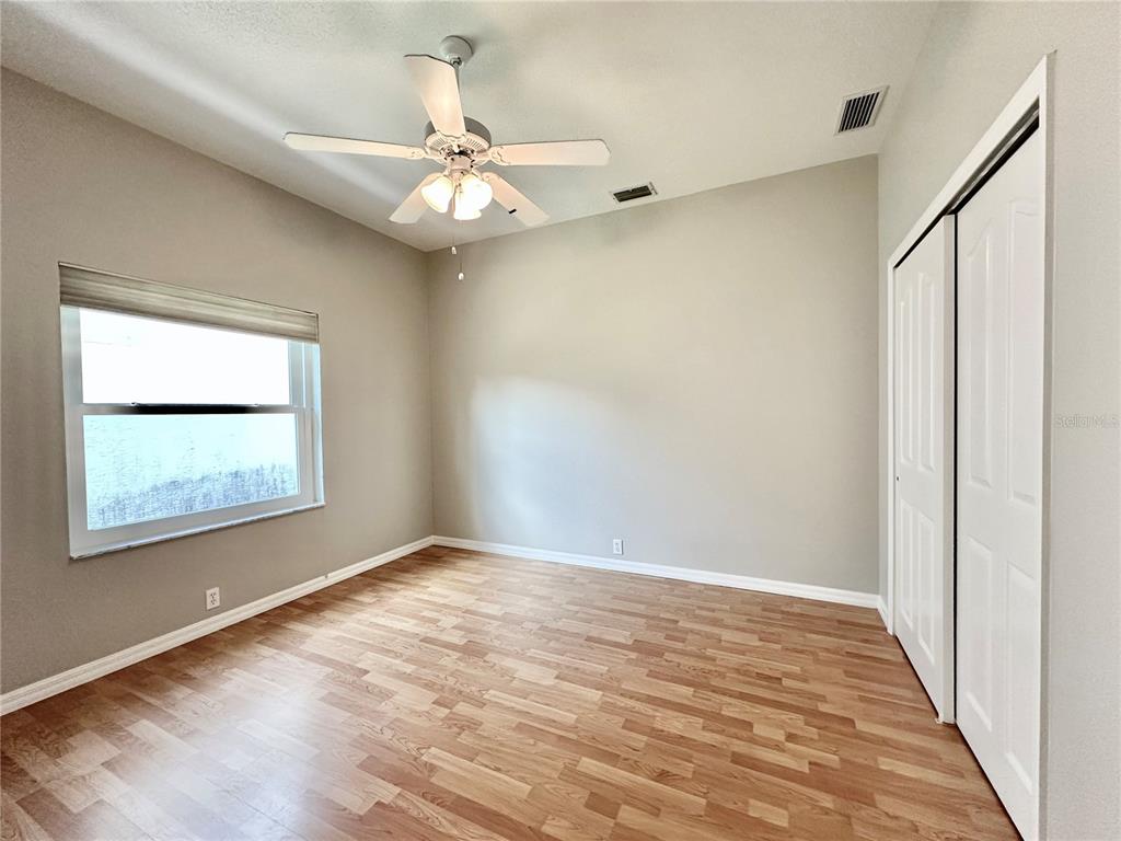 16 Westbrook Lane Palm Coast, FL 32164 - Photo 27 of 42 an empty room with wooden floor fan and windows