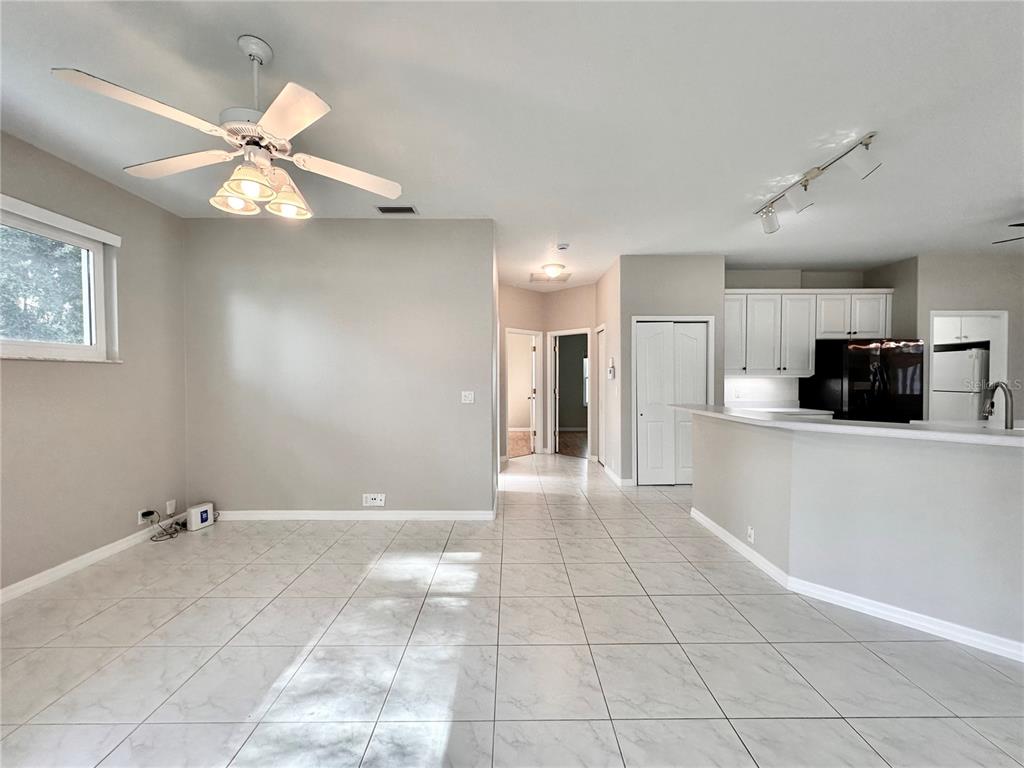 16 Westbrook Lane Palm Coast, FL 32164 - Photo 6 of 42 a view of an empty room and kitchen view with a ceiling fan