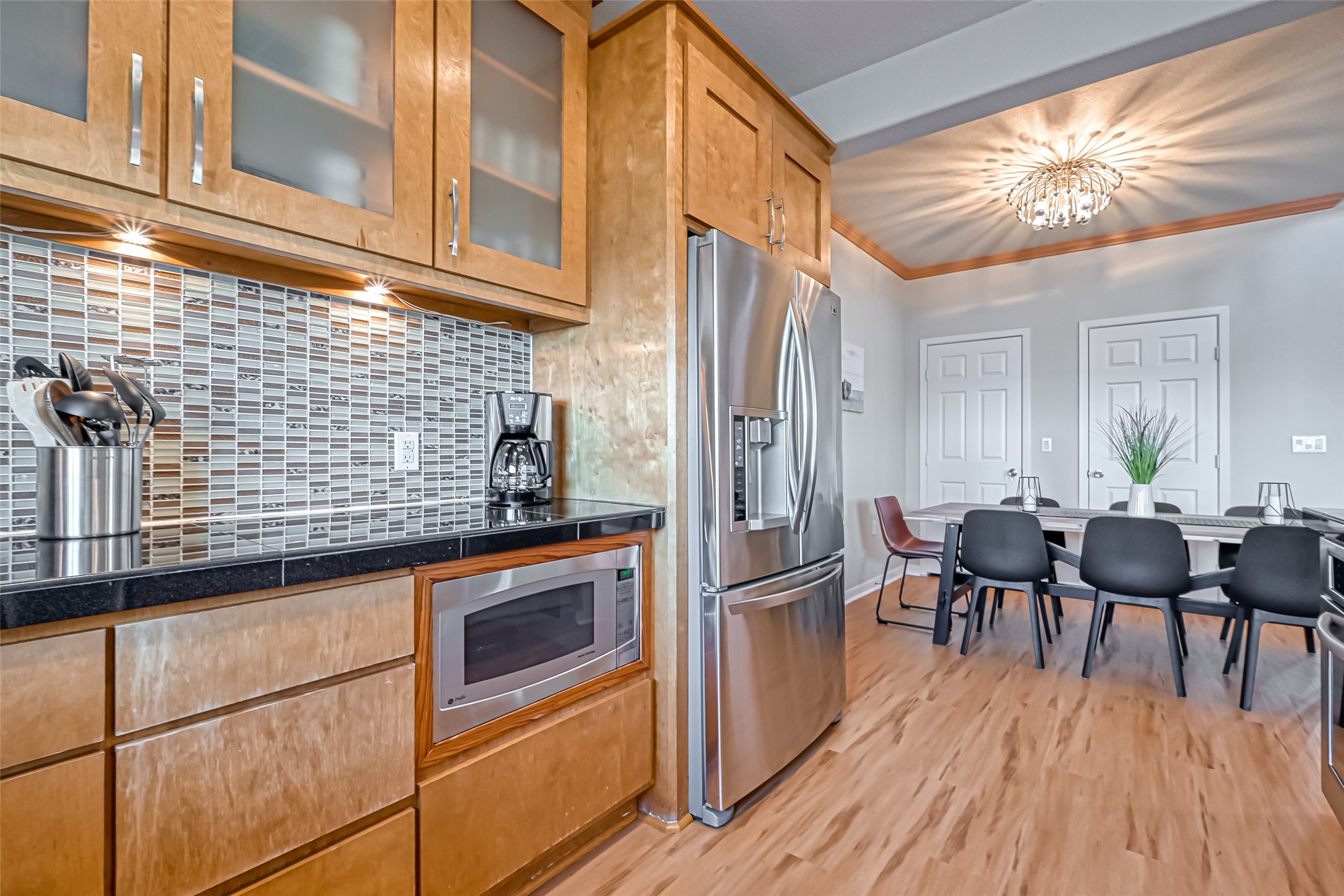 2102 Todville Road, Unit 9 Seabrook, TX 77586 - Photo 12 of 34 a kitchen with stainless steel appliances granite countertop a stove top oven a dining table and chairs with wooden floor