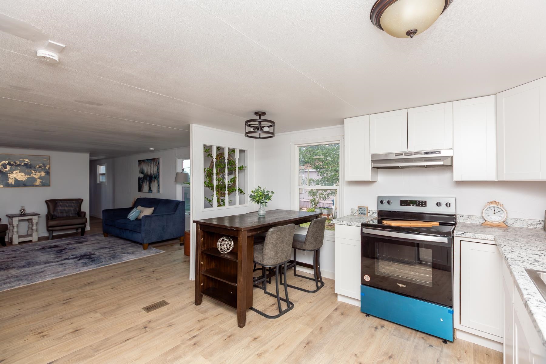 424 32 Road, Unit 112 Clifton, CO 81520 - Photo 9 of 41 a kitchen with stainless steel appliances granite countertop a stove a sink dishwasher and a microwave with wooden floor