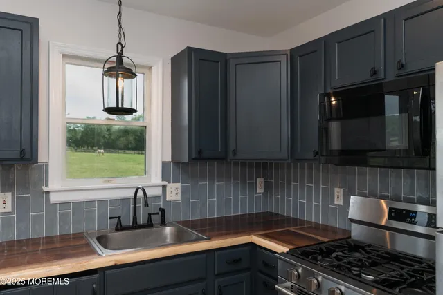 a kitchen with stainless steel appliances kitchen island wooden floors and large cabinets