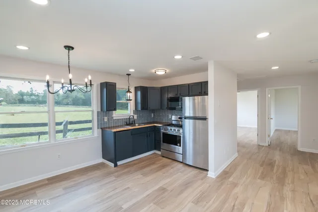 a kitchen with stainless steel appliances granite countertop a refrigerator and a stove top oven