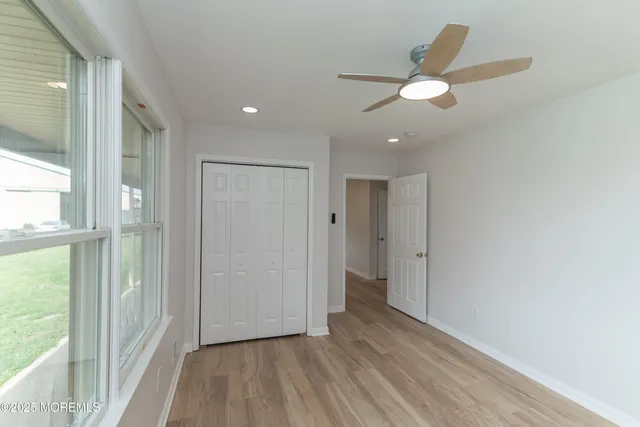 an empty room with a window and a ceiling fan