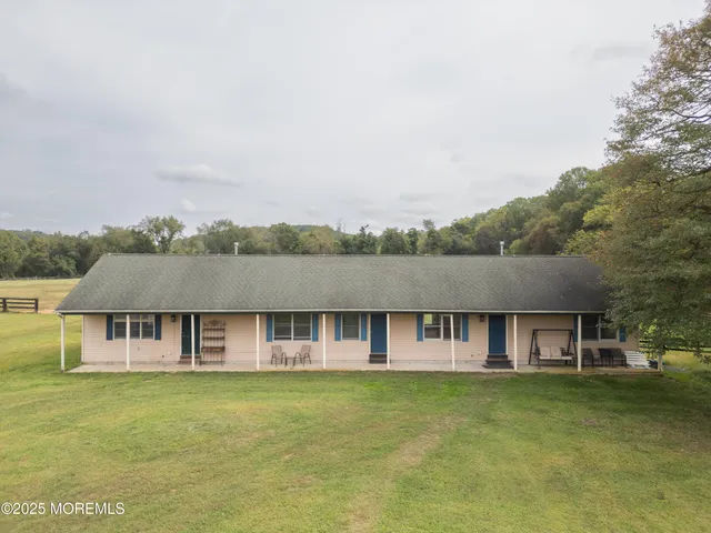 a front view of a house with a garden and trees