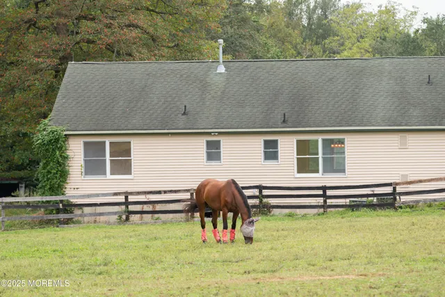 a view of a swimming pool with lawn chairs and a big yard