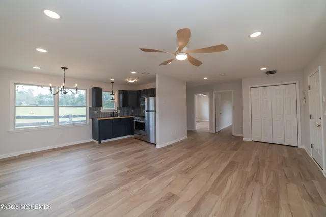 a large kitchen with stainless steel appliances granite countertop a large counter top and a wooden floor