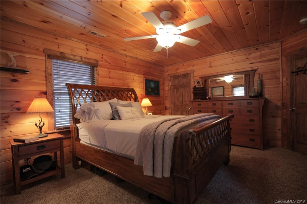 75 Stanley Dr Mill Spring Mill Spring, NC 28756 - Photo 26 of 48 a spacious bedroom with a bed and a ceiling fan