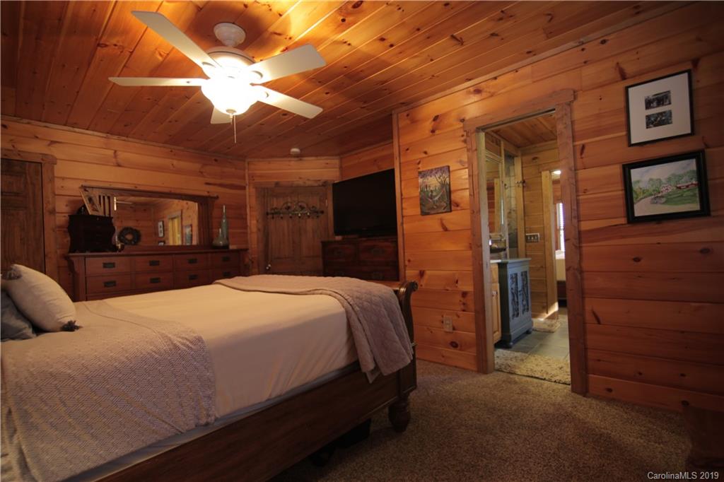 75 Stanley Dr Mill Spring Mill Spring, NC 28756 - Photo 27 of 48 a bedroom with a bed and a chandelier