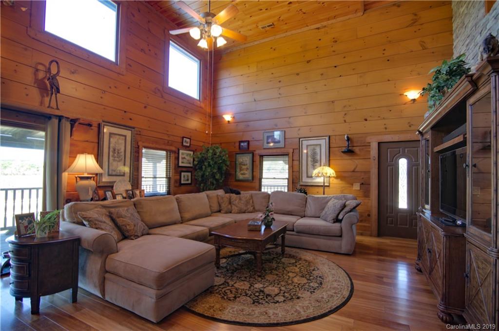75 Stanley Dr Mill Spring Mill Spring, NC 28756 - Photo 4 of 48 a living room with furniture a lamp wooden floor and a large window