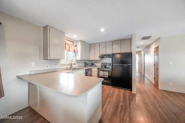 a large kitchen with kitchen island a sink stainless steel appliances and cabinets