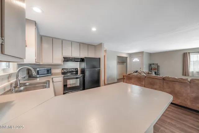 a kitchen with stainless steel appliances granite countertop a refrigerator sink and stove