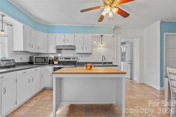 a kitchen with stainless steel appliances granite countertop a refrigerator a stove and white cabinets