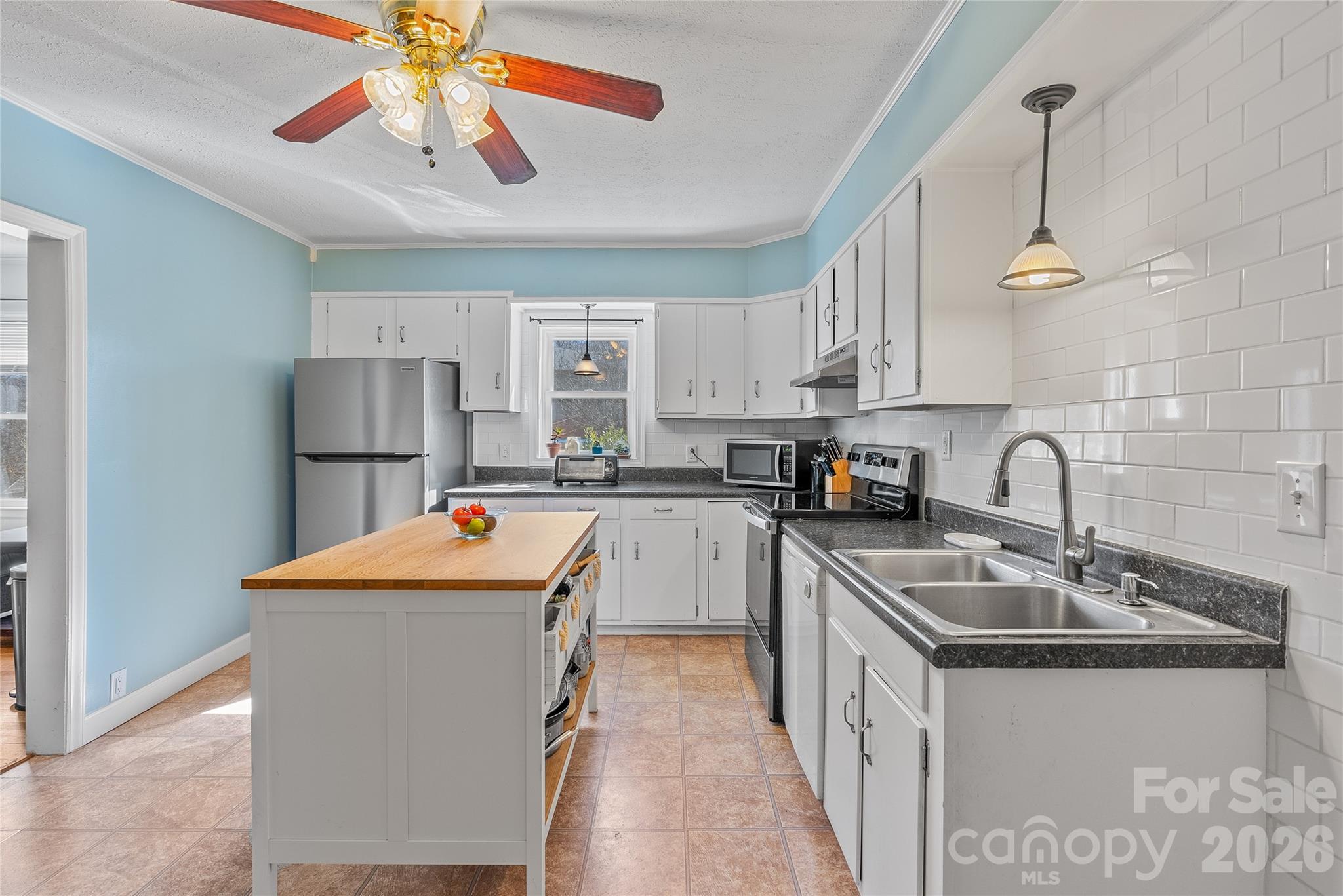 21 Ben Owenby Road Fairview, NC 28730 - Photo 10 of 38 a kitchen with stainless steel appliances granite countertop a sink a stove a refrigerator cabinets a dining table and chairs