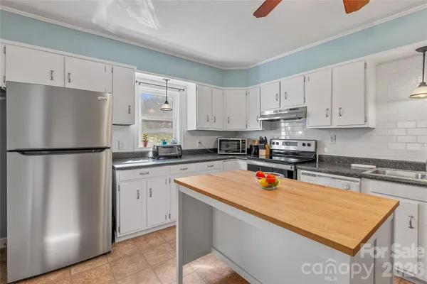 a kitchen with stainless steel appliances granite countertop a refrigerator a sink and a stove